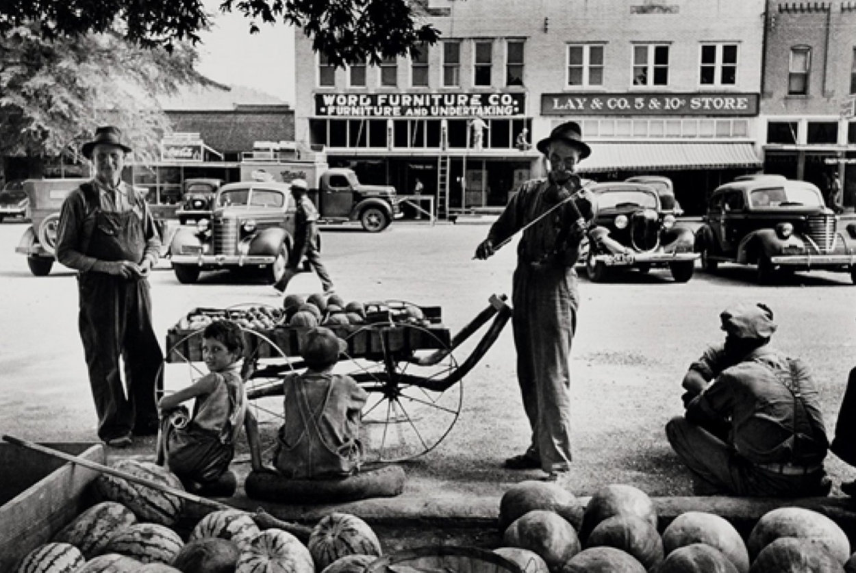 Melon Salesman And Fidler At a Marketplace in Scott, Mississippi Photography by Alfred Eisenstaedt